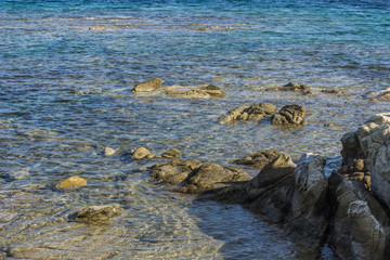tropic sea beach vivid blue water near sea shore with rocky bottom and stone above surface, summer vacation concept 