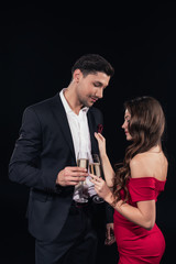 beautiful romantic couple holding champagne glasses isolated on black