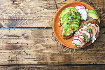 Cereal bread sandwiches with cottage cheese, fresh avocado and radish.