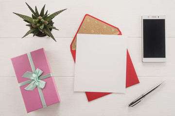 Red envelope, gift box, mobile phone, pen and flower on the table