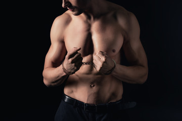 cropped view of shirtless man in handcuffs isolated on black