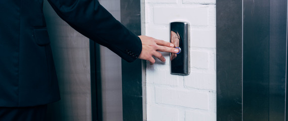 cropped view of man pressing elevator button