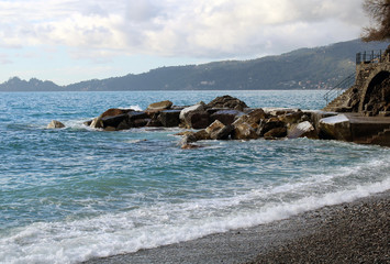 Fototapeta na wymiar Scogliera frangiflutto con spiaggia e mare agitato