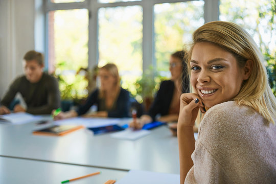 Portrait of smiling student sitting at table at university