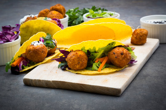 Sweet potato falafel in taco shells, with red cabbage, salad, carrot, yogurt sauce and black sesame