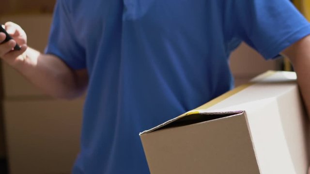 Courier hold box and taxt on phone. Package delivery concept
