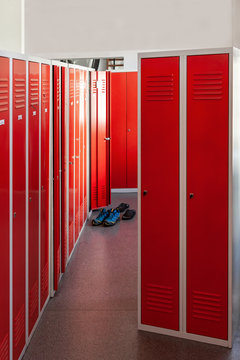 High school locker room with red shiny lockers. Fitness Gym. Concept of studying and getting knowledge.  Cloakroom with red cabinets in the fire department..