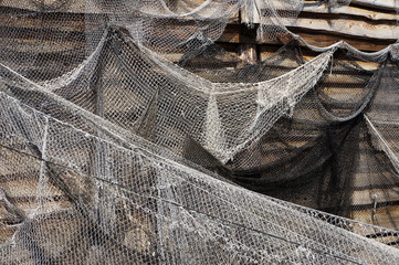 Fishing nets hanging on a wooden wall.
