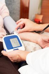 doctor measuring the blood pressure of a senior