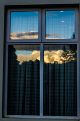 janela em vidro com reflexo do por do sol