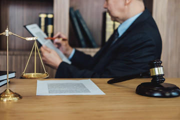 Gavel on wooden table and Lawyer or Judge working with agreement in Courtroom theme, Justice and...