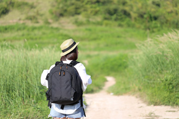Young woman traveler with backpack enjoying and standing on the road of the mountains background, Koh Larn in Pattaya city, Chonburi Thailand