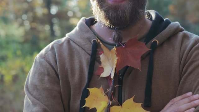 A young man with a beard and glasses smiling crooked teeth on his face acne, a man smokes a lot and drinks alcohol