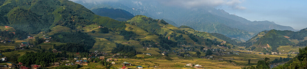 Fototapeta na wymiar Beautiful Panorama Top view of growing golden paddy rice field in Tavan local village with fansipan mountain and cloudy sky in background, Sapa, Laocai , Northwest of Vietnam