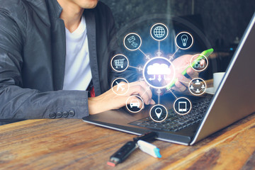 Internet of Things (IoT), Business man using laptop computer and hand holding mobile smart phone and iot icon or hologram with in home office, Communication network service and Business concept