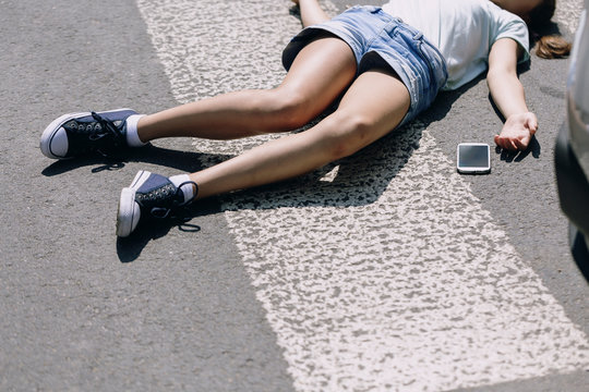 Unconscious Girl Lying On A Street Next To Her Mobile Phone