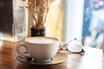 cup of coffee on old wooden desk. Simple workspace or coffee break in morning, selective focus