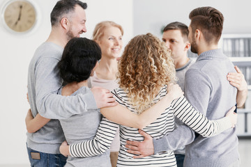 Men and women hugging each other during therapy for couples with problems