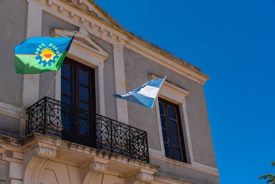 Buenos Aires province and Argentinan state flag flaming with a blue sky background on a balcony