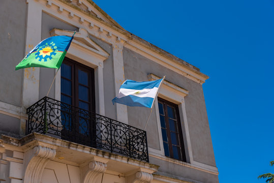 Buenos Aires province and Argentinan state flag flaming with a blue sky background on a balcony