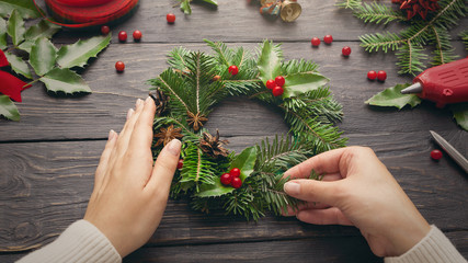 Female hands make Christmas wreath