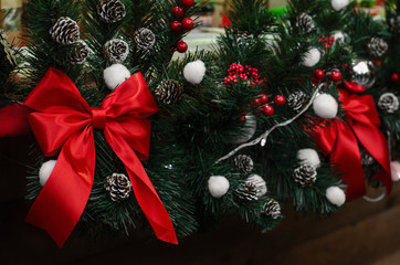 red ribbon bows  and fir tree with cones decorations on the street christmas fair in Lviv, Ukraine