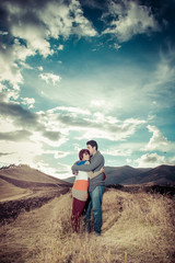 Fototapeta na wymiar Young couple hugging on an open field
