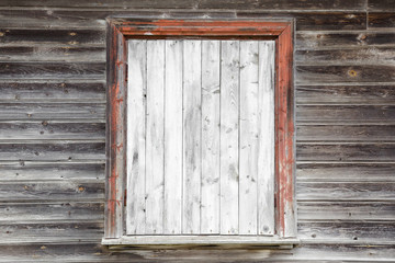 Boarded up window with light gray planks. Old weathered wooden wall. Part of abandoned house. Mock up for different ideas. Empty place for text or objects.
