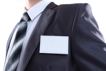 Blank identity tag hanging from a businessmans suit