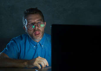 lascivious aroused porn addict man in nerd glasses watching sex movie online late night at laptop computer looking pervert and horny in internet pornography sex content