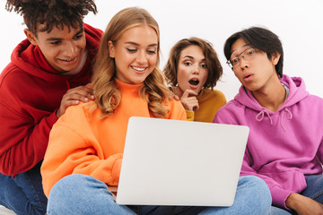 Group of friends students isolated over white wall background using laptop computer.