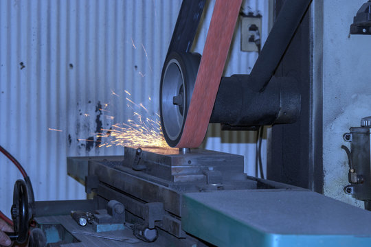 A sander throws sparks in the workshop.