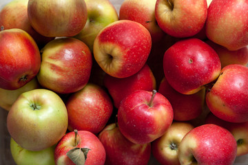 Several ripe red apples lay in layer