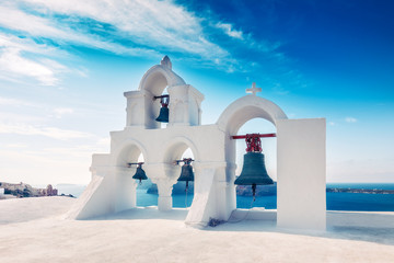 Church bells in Oia village, Santorini island in Greece, on a sunny day with dramatic sky. Scenic...