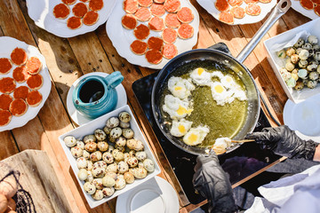 Fresh quail eggs fried in oil in a showcooking