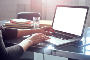 Woman with blonde short hair analyst working at co-working office on laptop, book, daylight. Hands typing on the notebook keyboard.Concept of young people work mobile devices.Space for design layout.