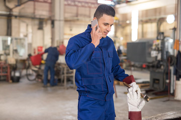 Male engineer being lazy and talking on the phone while he's on duty