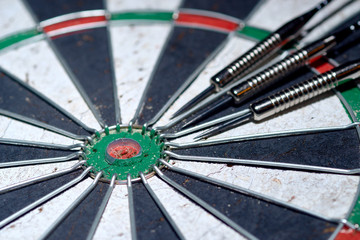 Three darts lying on a dartboard