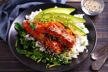 Salmon in honey-soy glaze with rice, spinach and avocado. horizontal