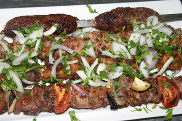 Roast meat known as shashlik and lulah kebab served with onion and parsley