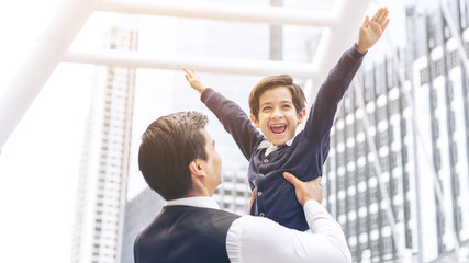 Father carries son playing aviator air plane imagination dreaming of being a pilot future on business district urban, Dad and Son happy family concept