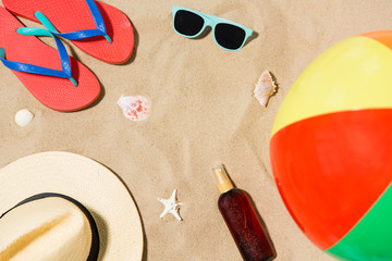 vacation and summer holidays concept - straw hat, flip flops, sunglasses, beach ball and sunscreen...
