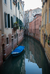 Fototapeta na wymiar A narrow canal between the houses in Venice