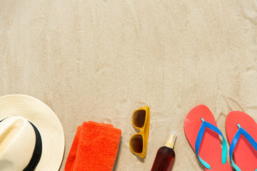 vacation, travel and summer holidays concept - straw hat, flip flops, sunglasses and sunscreen oil...