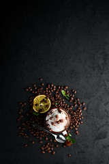 Cappuccino with milk and nuts and marshmallow. On a black stone background. Top view. Free copy space.