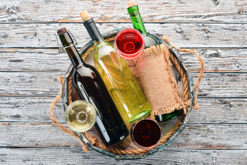 Set of red and white wine in bottles and glasses. Grape. On a white wooden background. Free space...