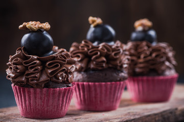 Dark chocolate cupcake on wooden board
