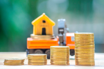 House or Home model on near of coins stack with home key on hand. Concept for loan, property...