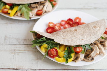 Sandwich with whole wheat wrap, chicken breast, mushrooms and seasonal vegetables and herbs. Balanced and healthy food