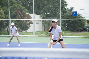 Two female tennis players are preparing to take the tennis ball from the opponent.